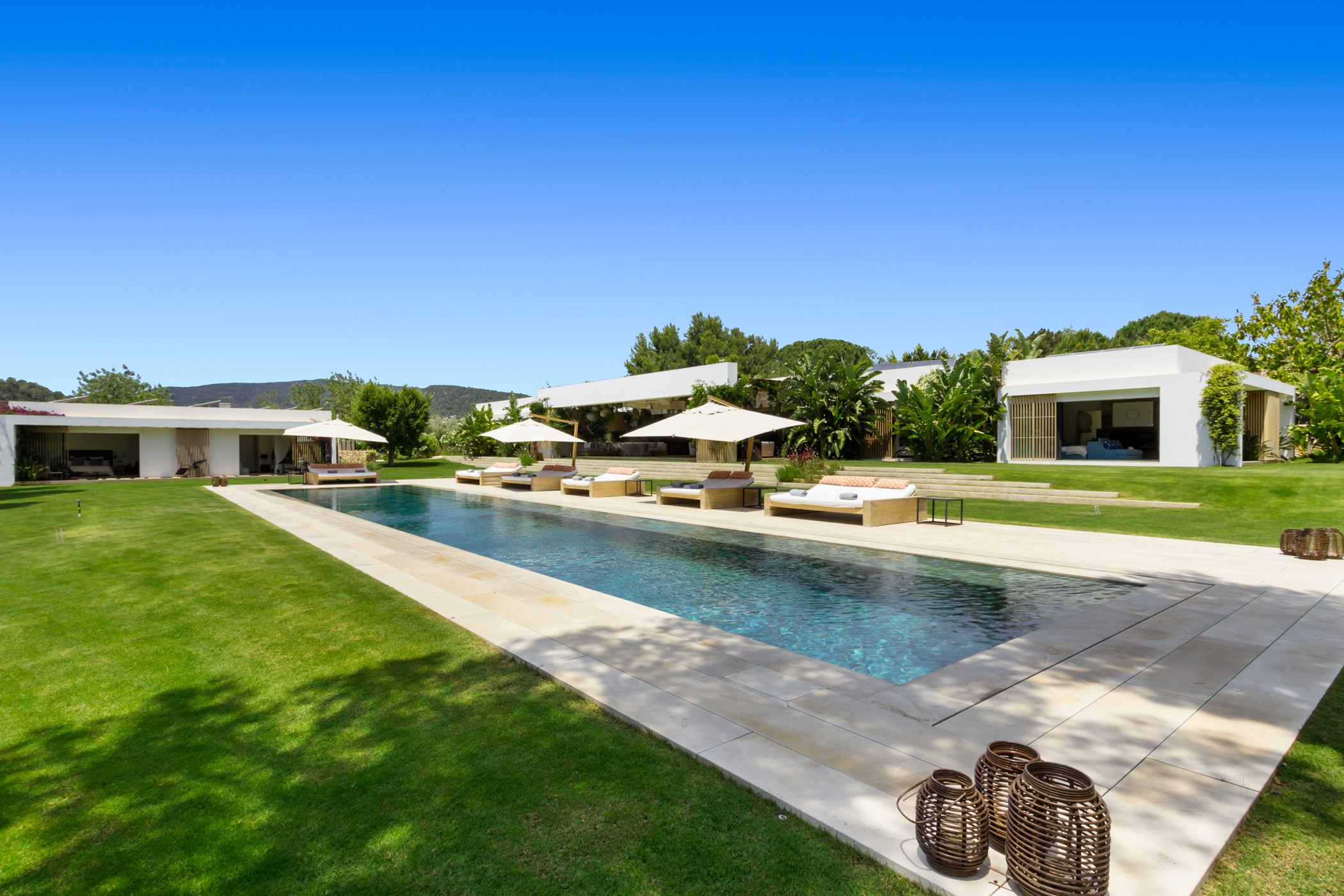 Sunloungers and parasols arranged along the edge of the long infinity pool